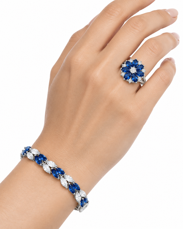 Anillo y pulsera floral azul de plata sobre fondo blanco